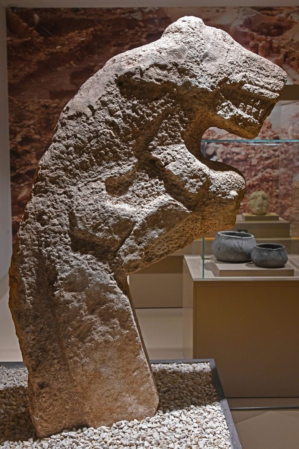 A Karahan Tepe statue of a human with a leopard climbing its back — two beings combined into one carved object, the same stacked-being logic as the totem pole.