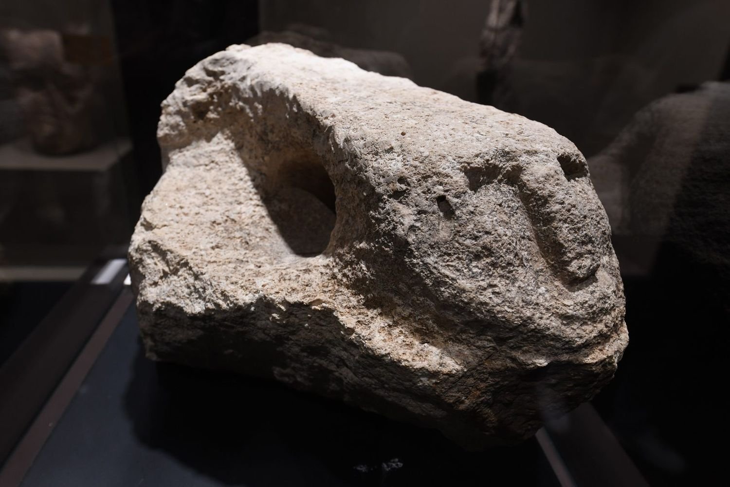 A pillar fragment from Karahan Tepe carrying a human head in relief — heads keep appearing across the network, in stone, on pillars, and in the wall.