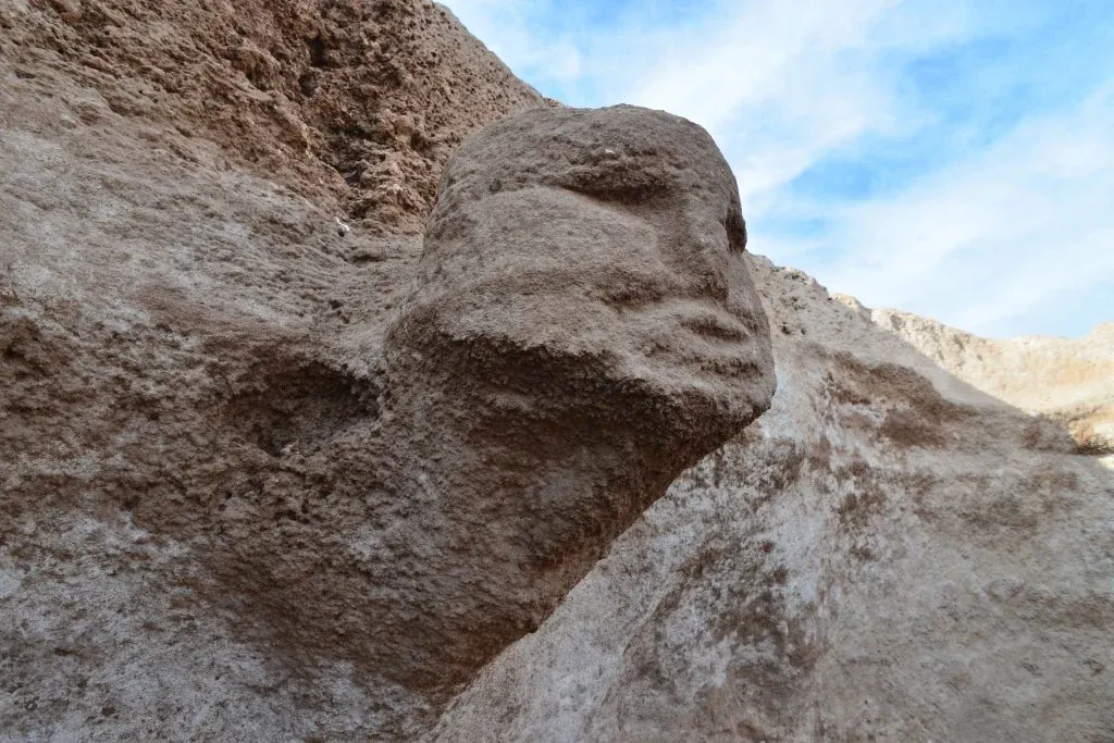 The same Karahan head, close up: a life-size face carved out of the living rock so that it seems to lean out of the wall — the human head made permanent, and set to watch over the room.