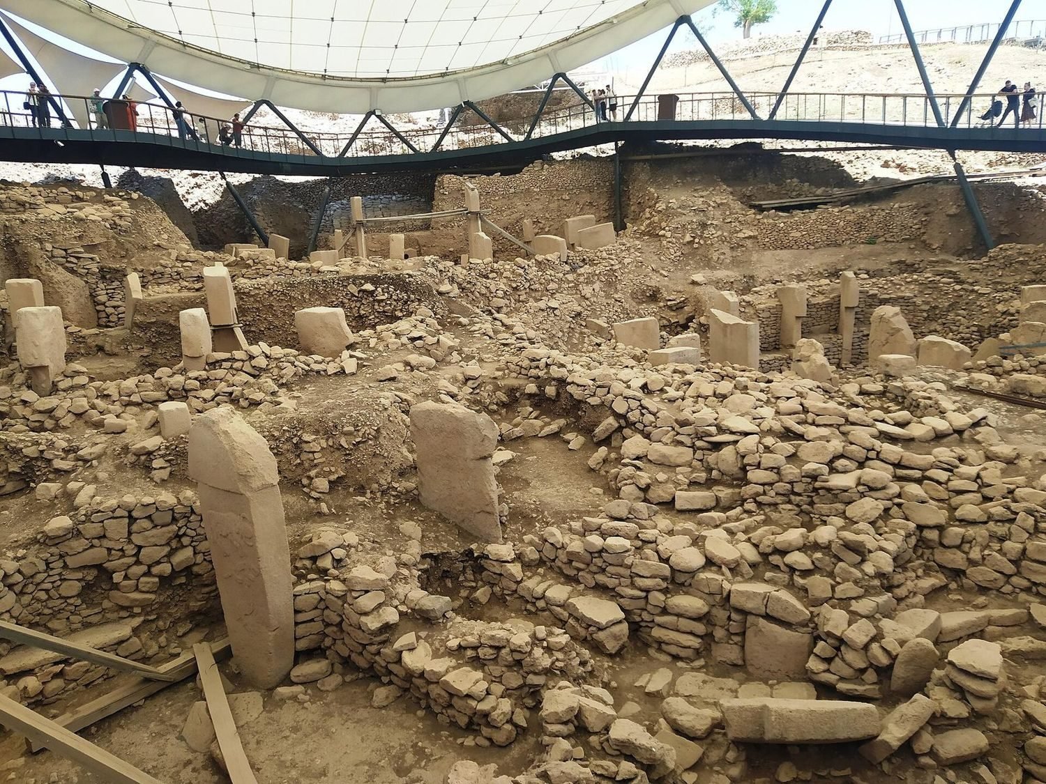 The dug enclosures with their great T-pillars — the part of Göbekli Tepe visitors see. Reporting on the site commonly reckons this at around ten percent of the whole tell.