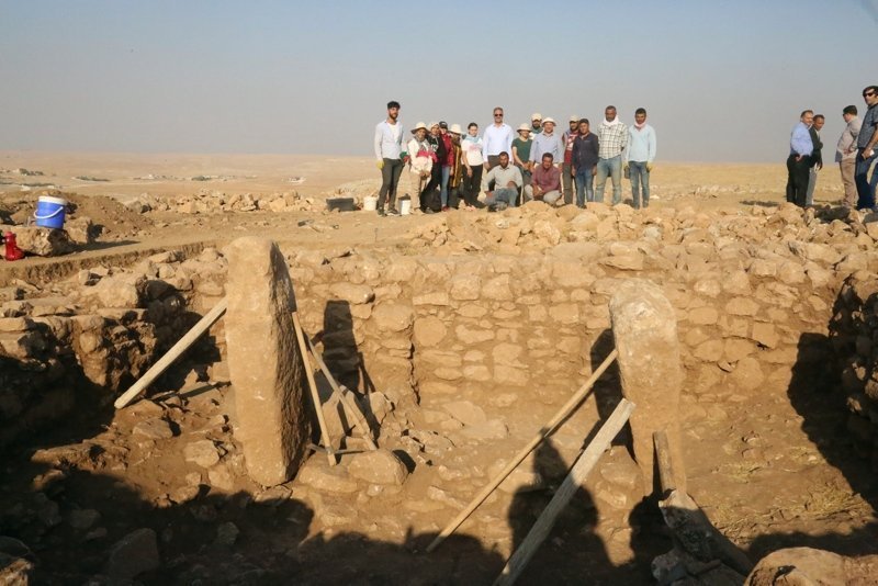 Excavation in progress at Harbetsuvan, with a standing stone set within a drystone-walled building — the small-scale architecture of an ordinary Neolithic village, not a monumental sanctuary.