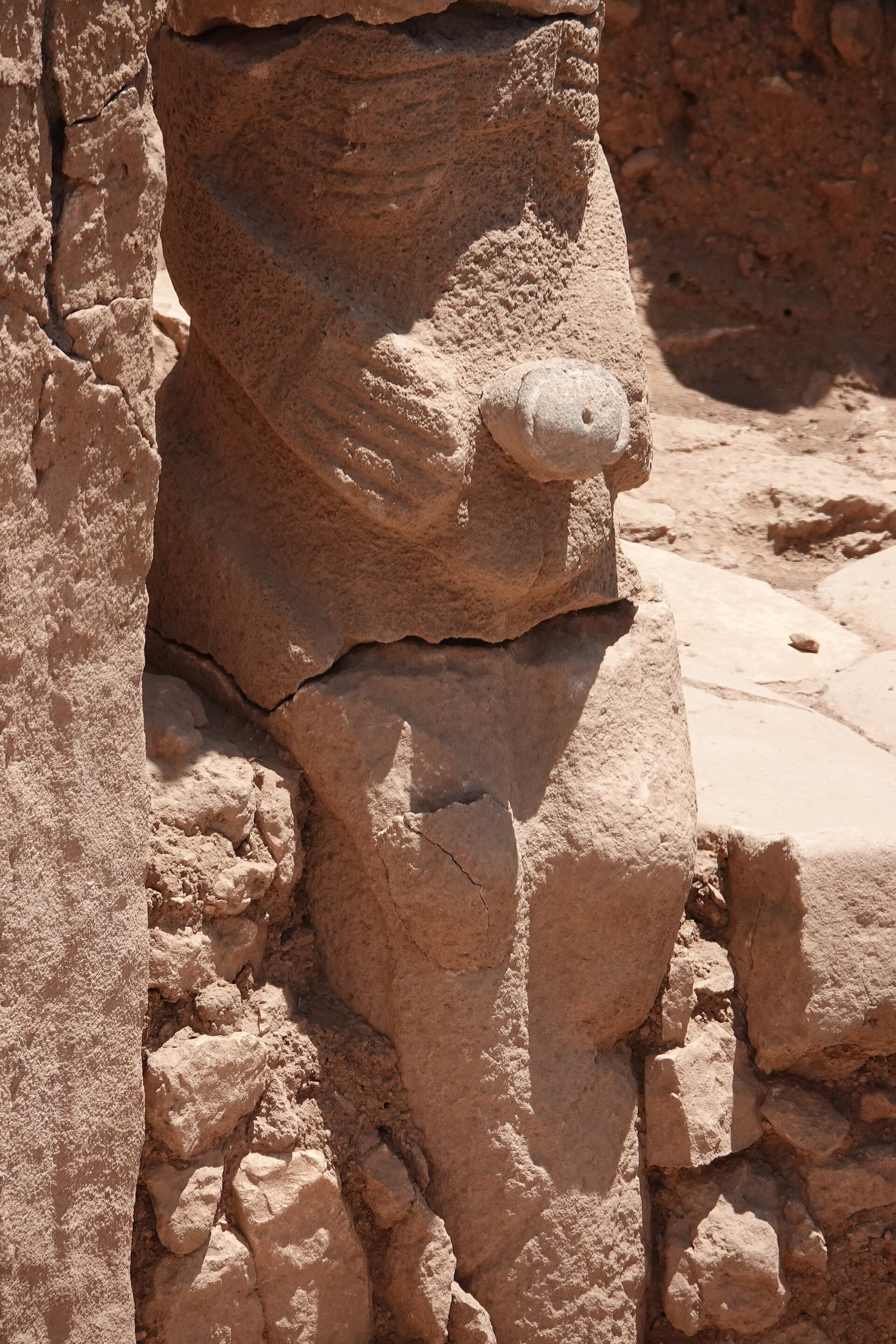 A large human figure at Karahan Tepe, carved with deeply marked ribs, hands meeting at the front, and pronounced genitalia.