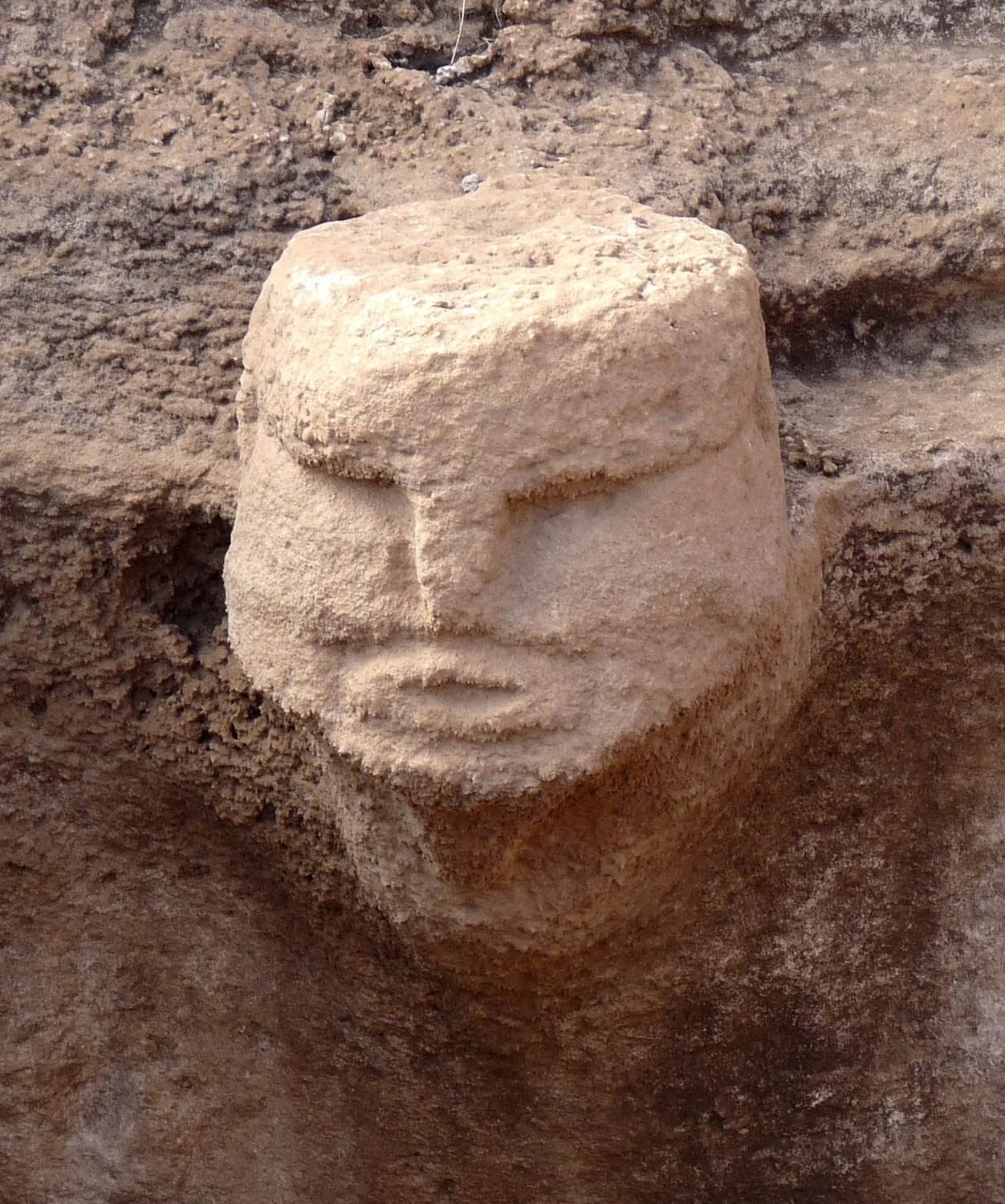 Close-up of a Karahan Tepe carved face, showing the detail of the features cut into the stone.