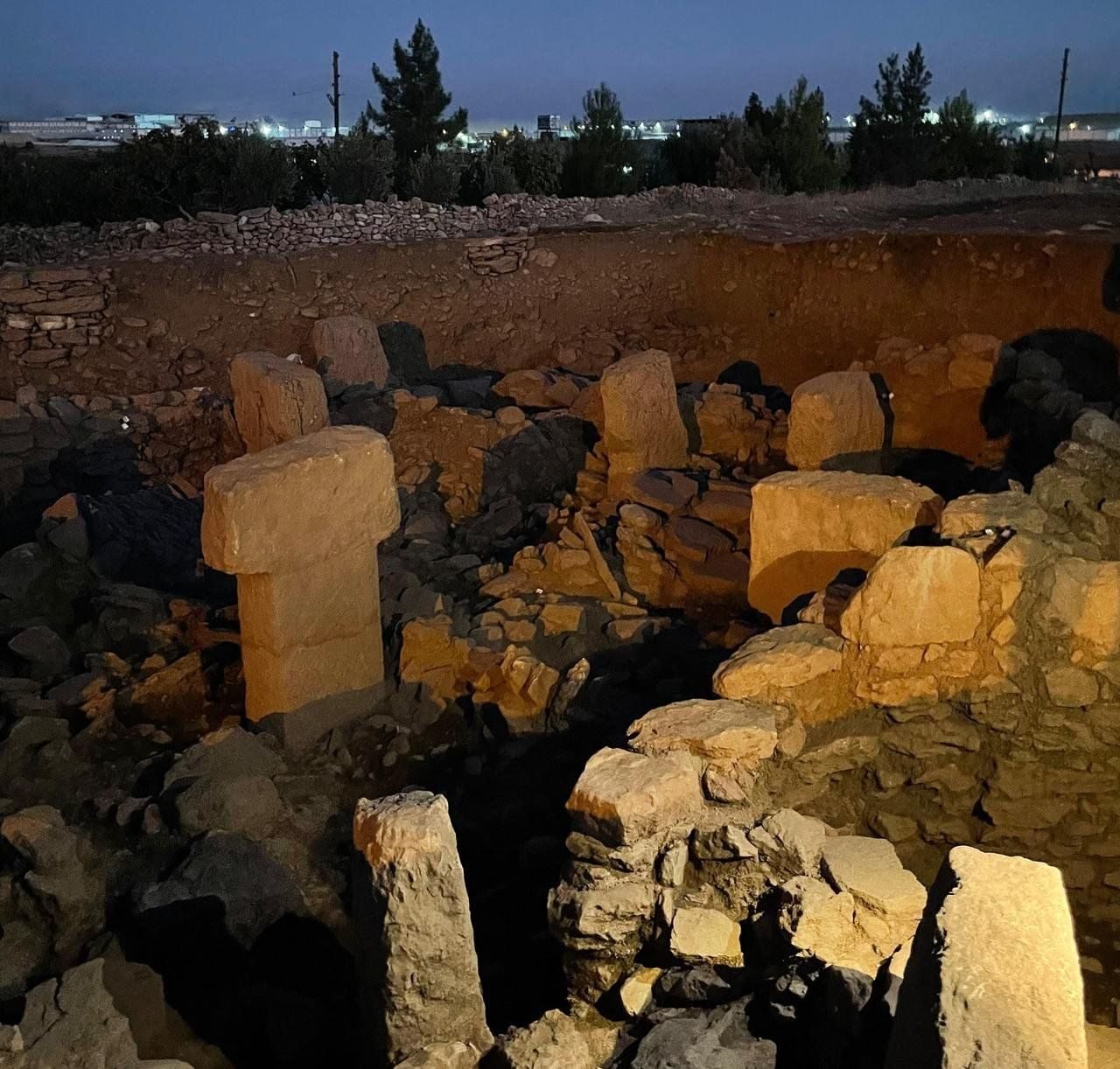 A carved special building under lights at the Sayburç excavation at night