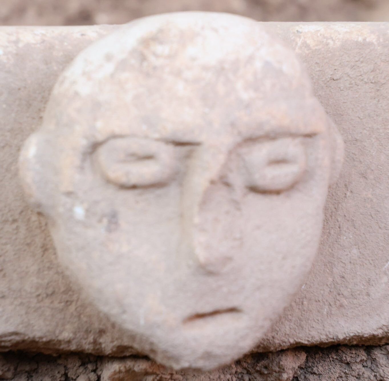 A human face carved on a dressed block from Sefertepe — the same site whose 2024 'skull room' held a group of human skulls, one set apart and facing east.