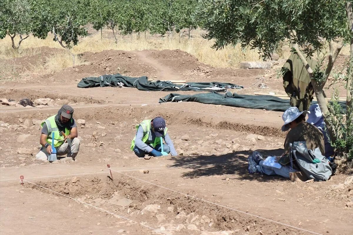 Excavators working a trench at Yoğunburç. This opening season aims to trace the site's edges and find where material concentrates, rather than expose monuments.