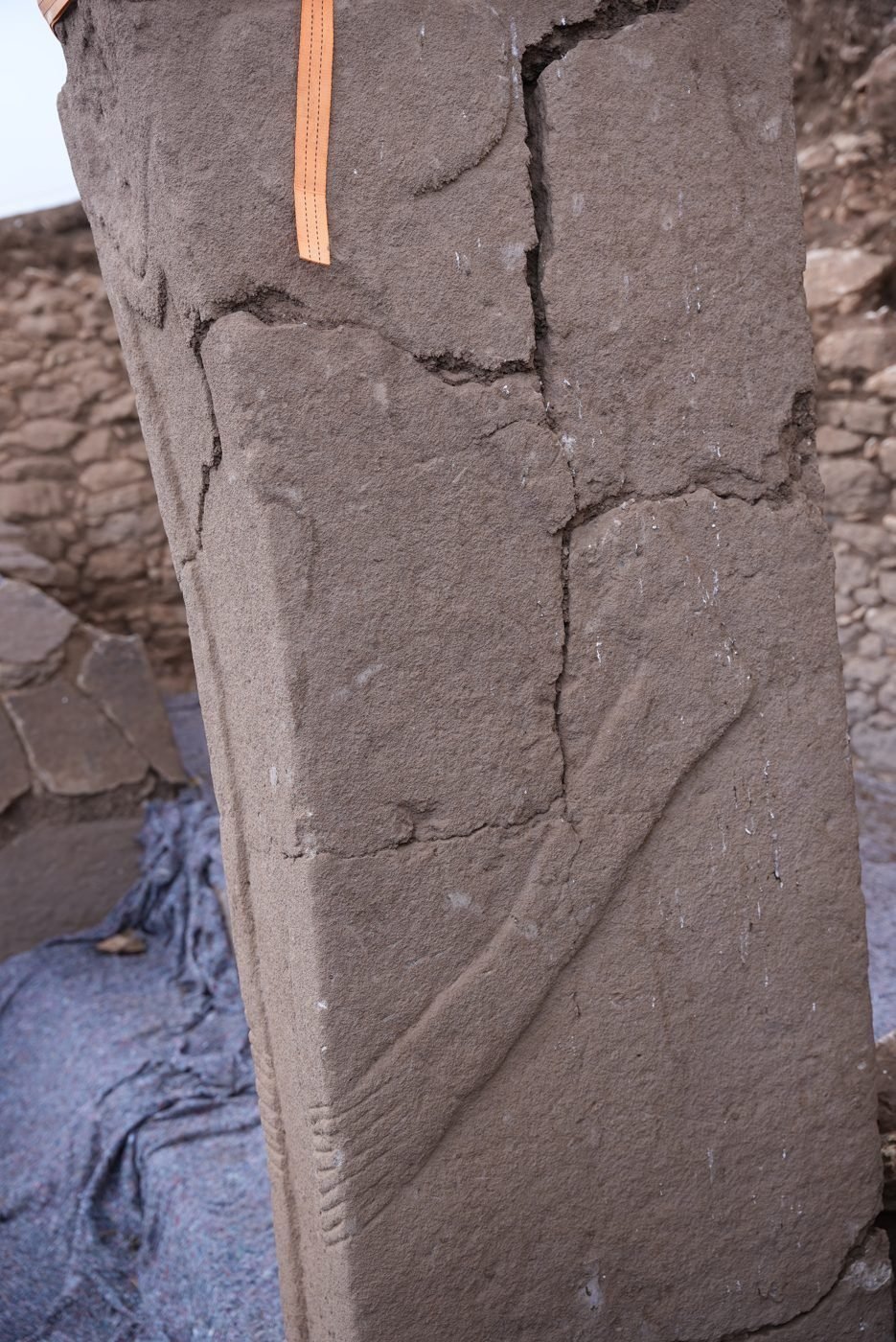 Higher up, the 'arm': a shallow relief band runs down the long side of the pillar and turns toward the front — but note where it meets the shoulder, which sits differently from the clean arm-to-shoulder junction on a typical T-pillar.